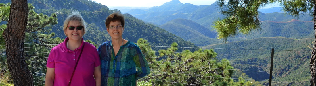 Woman smiling with mountainous forest landscape behind her.