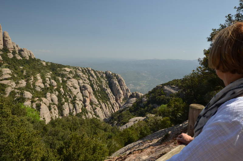 View of rocky cliffs and distant city from a mountain.
