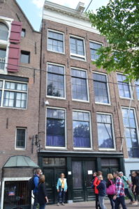 Tall building with large windows and brick facade.