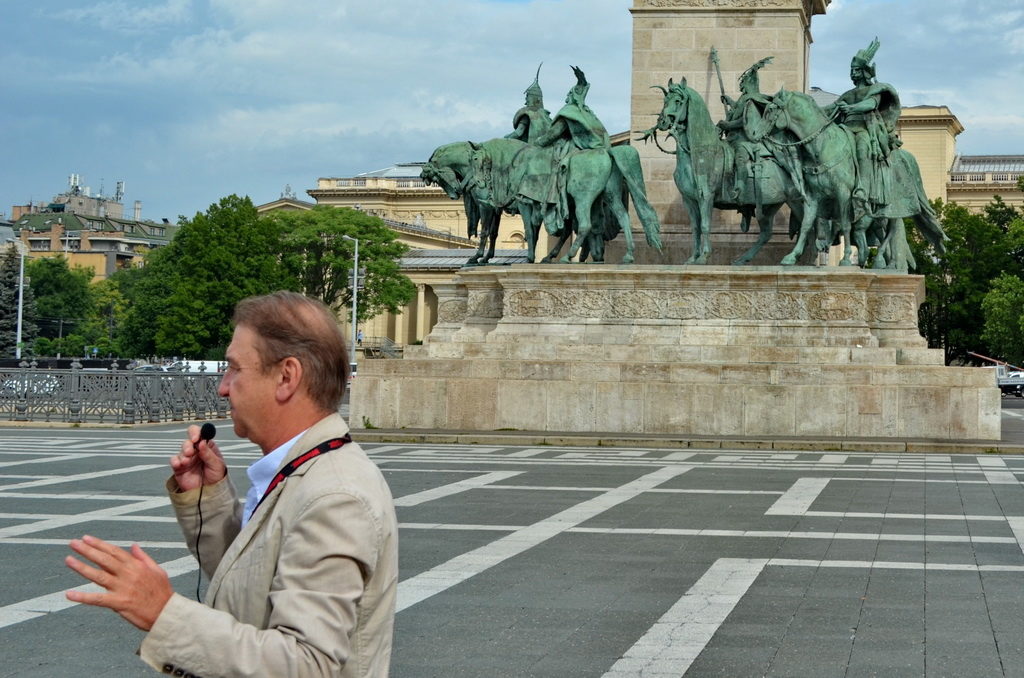 Man enjoying a popsicle near a historic equestrian statue.