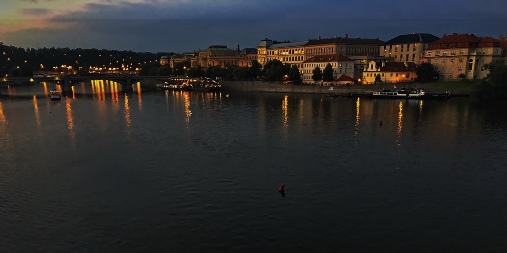 A lush green valley with a river flowing through mountainous terrain under a cloudy sky.
