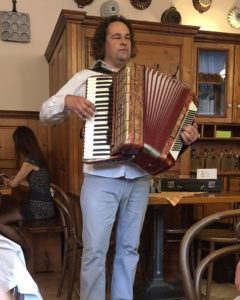 A lush green valley with a river flowing through mountainous terrain under a cloudy sky.