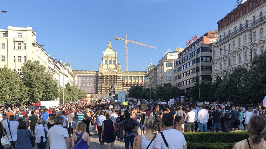 A lush green valley with a river flowing through mountainous terrain under a cloudy sky.