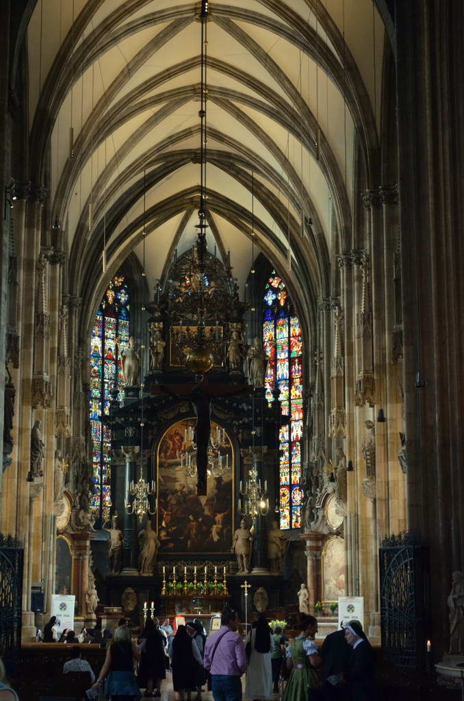 Interior view of a grand Gothic cathedral with stained glass windows.