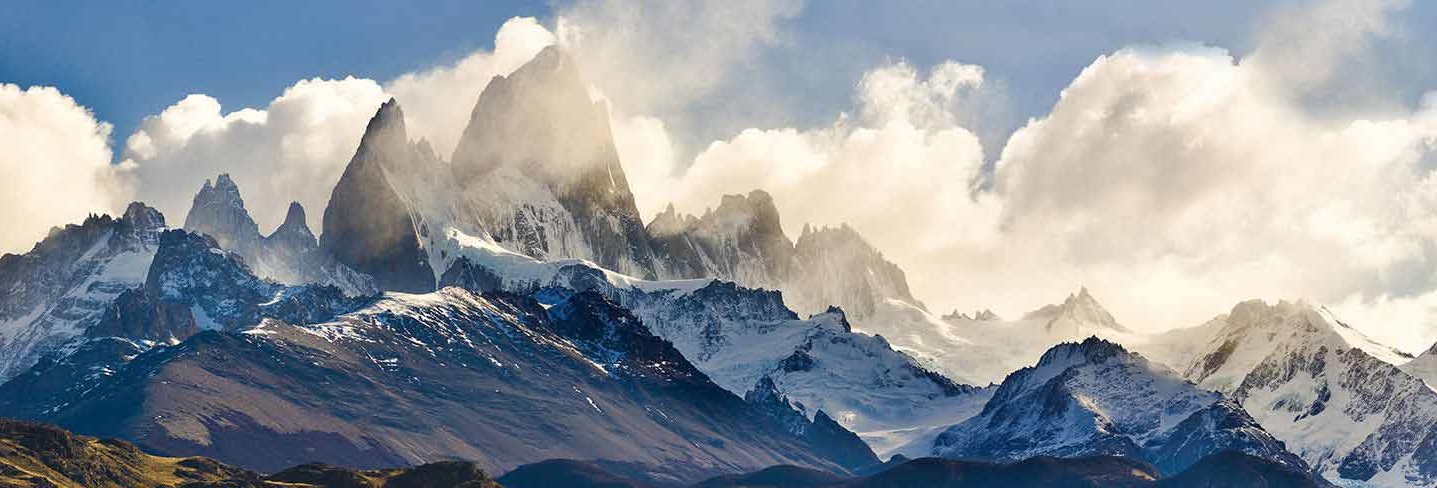 Snow-covered mountain peaks under a cloudy sky.