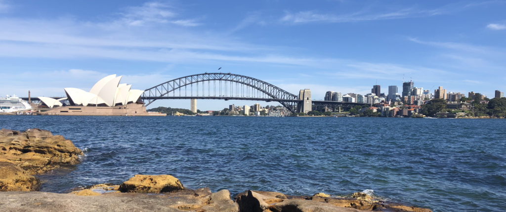 View of Sydney Harbour Bridge over blue water under a clear sky.