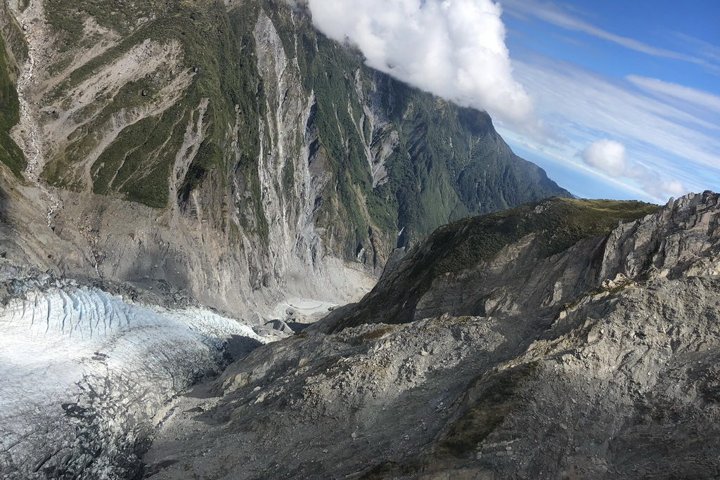 Mountain landscape with rocky cliffs and clouds above.