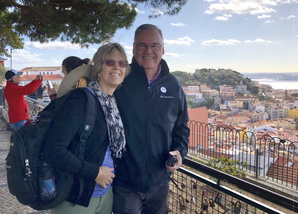 A lush green valley with a river flowing through mountainous terrain under a cloudy sky.