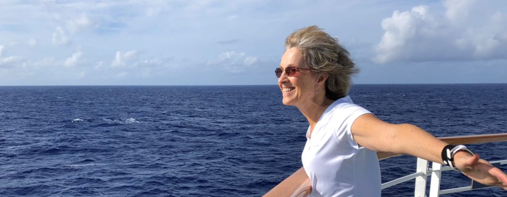 Man enjoying the ocean breeze on a ship deck.