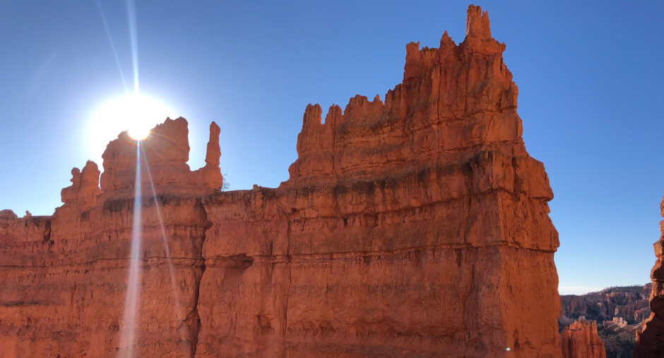 Sunlit red rock formations under a clear blue sky.