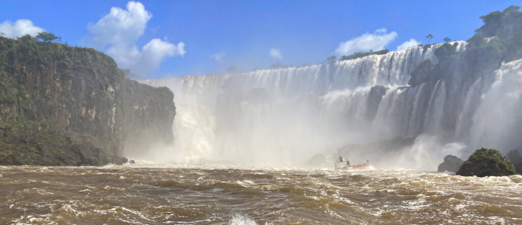 A lush green valley with a river flowing through mountainous terrain under a cloudy sky.