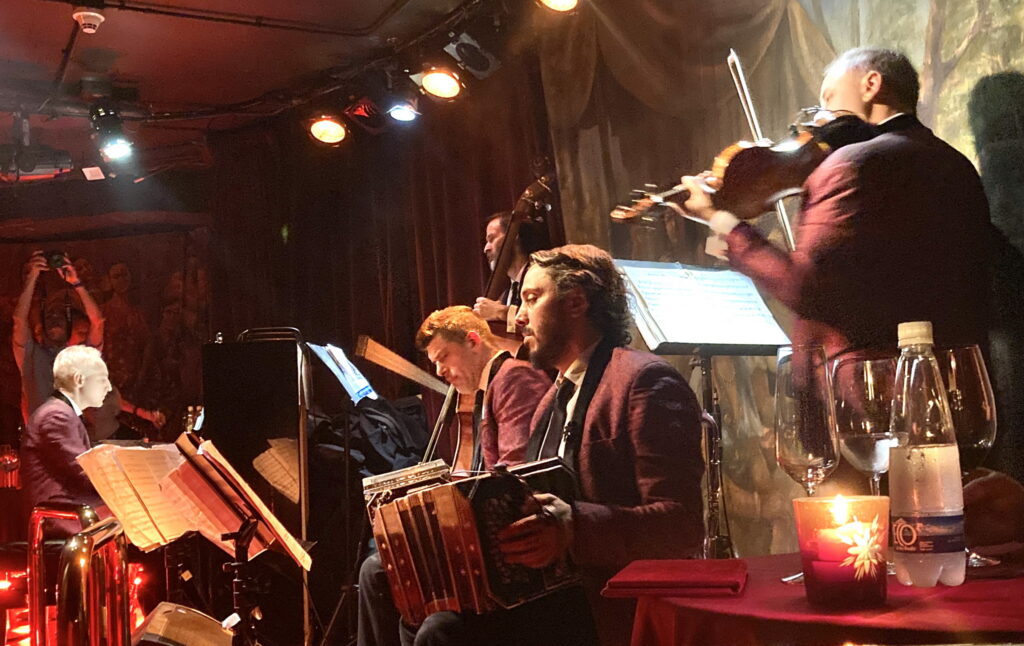 A lush green valley with a river flowing through mountainous terrain under a cloudy sky.