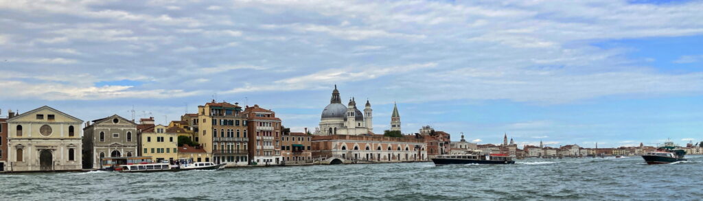 A lush green valley with a river flowing through mountainous terrain under a cloudy sky.