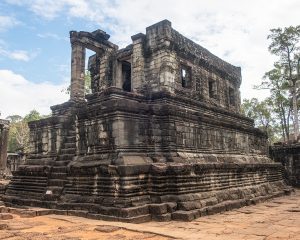 A lush green valley with a river flowing through mountainous terrain under a cloudy sky.