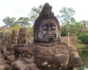 A lush green valley with a river flowing through mountainous terrain under a cloudy sky.