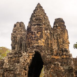 A lush green valley with a river flowing through mountainous terrain under a cloudy sky.